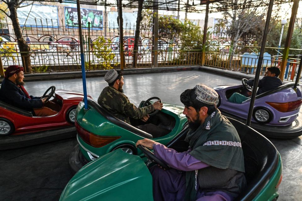 In this picture taken on November 23, 2021, Taliban fighters ride on bumper cars, while they visit a small amusement park during a day off, in Herat city, Herat.