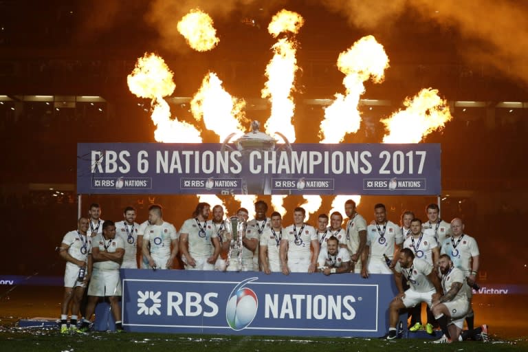 England players celebrate with the trophy after winning the Six Nations Championship on the pitch after the Six Nations international rugby union match between Ireland and England at the Aviva Stadium in Dublin on March 18, 2017