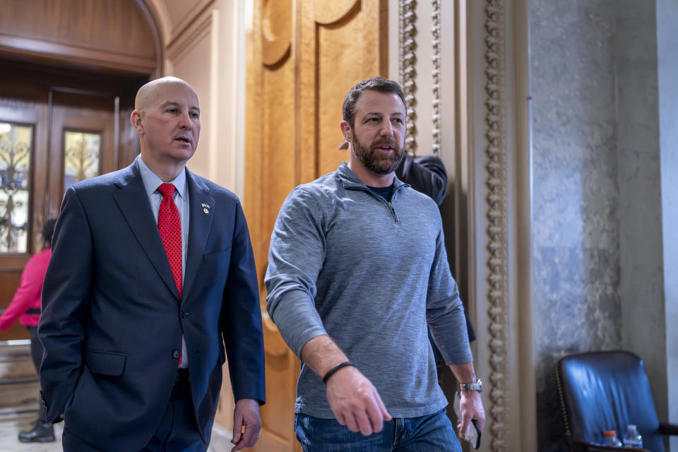 Sen. Pete Ricketts, R-Neb., left, and Sen. Markwayne Mullin, R-Okla., finish for the night as the Senate holds a procedural vote on a package of wartime funding for Ukraine, Israel and other U.S. allies, at the Capitol in Washington, Friday, Feb. 9, 2024. (AP Photo/J. Scott Applewhite)