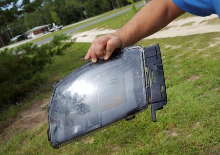 Robert VanKavelaar shows a piece of the Tesla found in his property where the Tesla came to rest when its driver was killed in a collision with a truck in May in Williston, Florida, U.S. July 1, 2016. REUTERS/Barbara Liston