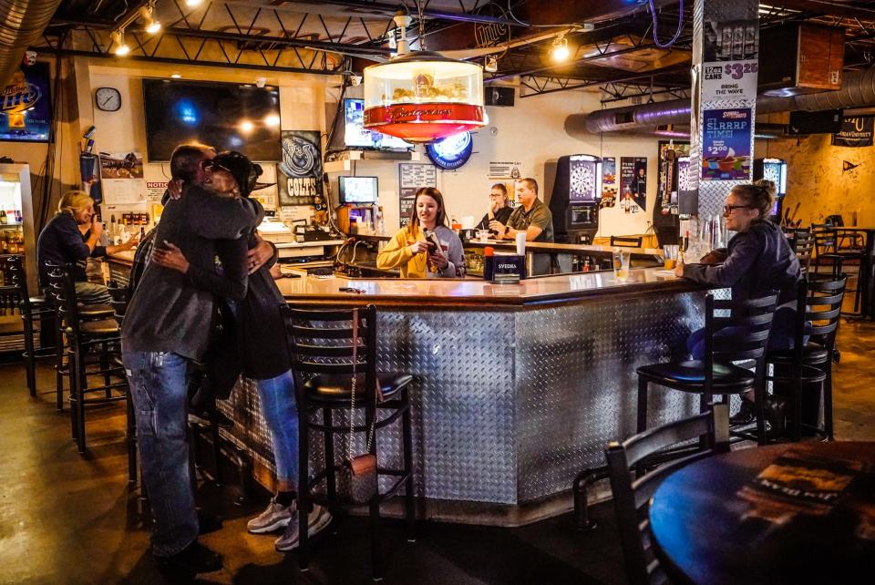 Regular Linda Foster, hugging, right, gets a big hug from a fellow regular during the lunch rush on Monday, June 12, 2023, at the Fat Cat Bar, located in the Eagledale neighborhood of Indianapolis.