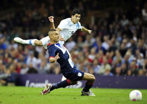 Uruguay's striker Luis Suarez takes a shot past Britain's defender Steven Caulker in the London 2012 Olympic Games men's football match between Britain and Uruguay at the Millennium Stadium in Cardiff, Wales. Hosts Great Britain won through to the Olympic men's football quarter-finals after Daniel Sturridge's goal secured a 1-0 win over Uruguay