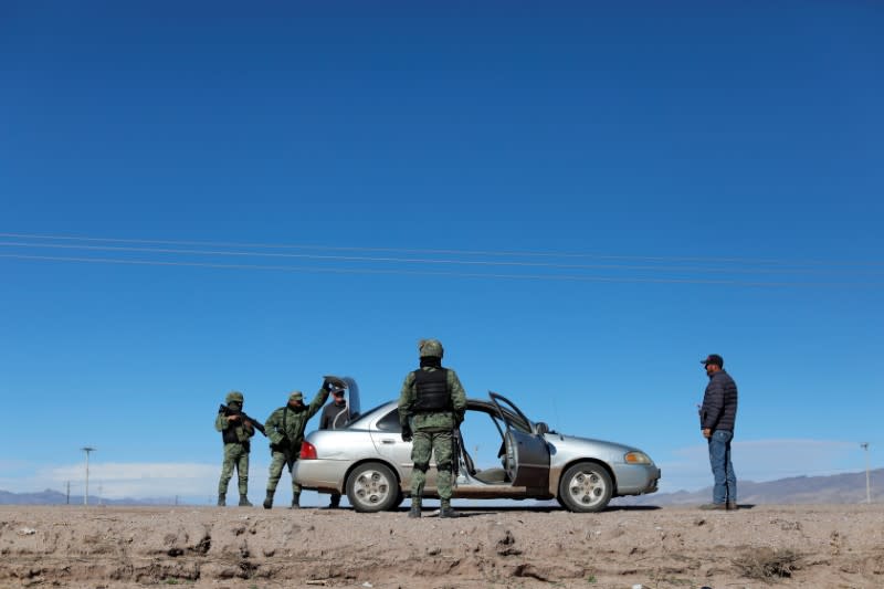 Soldiers check a vehicle at a check point in Janos, Chihuahua