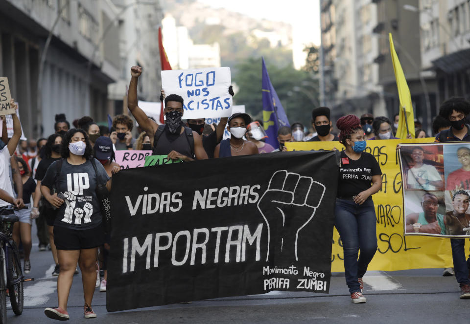 FILE - In this June 11, 2020 file photo, people holding a banner that reads "Black Lives Matter" march during a protest against racism and police violence amid the new coronavirus pandemic in Niteroi, Rio de Janeiro, Brazil. Afro-Brazilian demonstrators outraged by the death of -14-year-old João Pedro Matos Pinto at the hands of police have been organizing the largest anti-police brutality demonstrations in years on the streets of Rio. (AP Photo/Silvia Izquierdo, File)