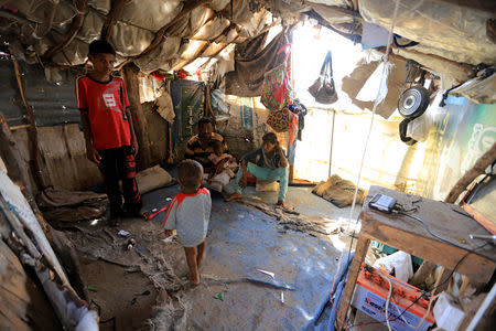 Ahmad Ali Bahr, 38, sits with his children in a shanty town in Hodeidah, Yemen March 25, 2019. REUTERS/Abduljabbar Zeyad