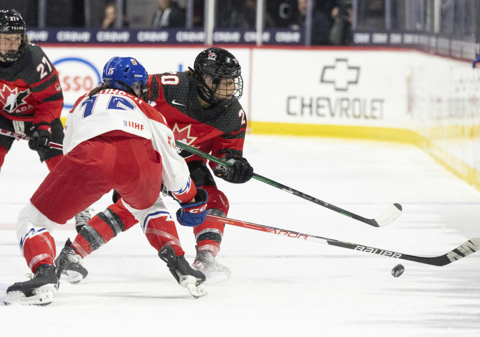 Canada's Sarah Nurse (20) battles past Czechia's Andrea Trnkova (15) during the second period of a hockey match at the IIHF Women's World Championships in Utica, N.Y., Sunday, April 7, 2024.(Christinne Muschi/The Canadian Press via AP)