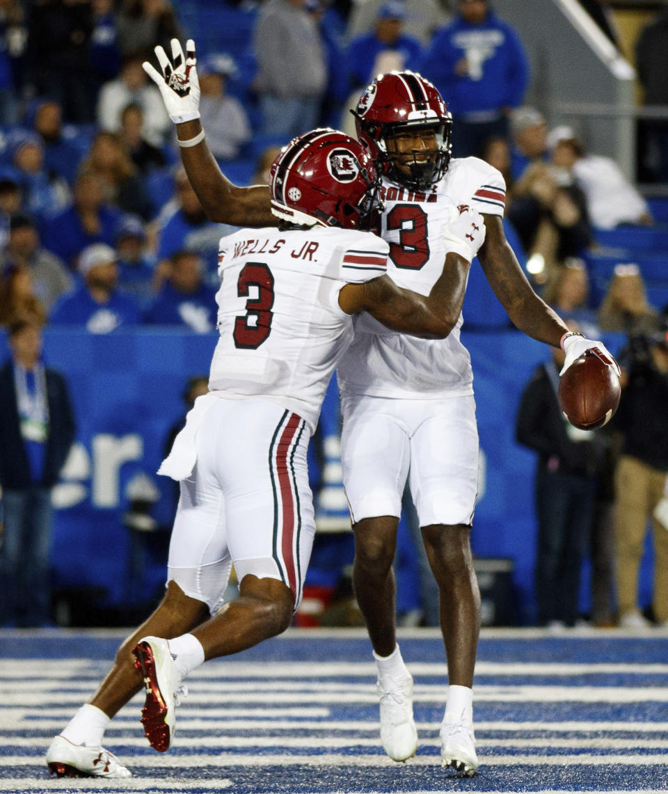 South Carolina wide receiver Jalen Brooks (13) waves to the Kentucky crowd while celebrating with wide receiver Antwane Wells Jr. (3) after scoring a touchdown during the second half of an NCAA college football game in Lexington, Ky., Saturday, Oct. 8, 2022. (AP Photo/Michael Clubb)