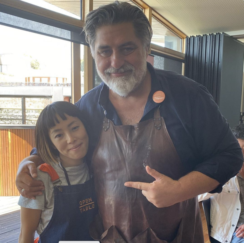 A photo of Matt Preston wearing a blue shirt and leather apron with a woman from Open Table.