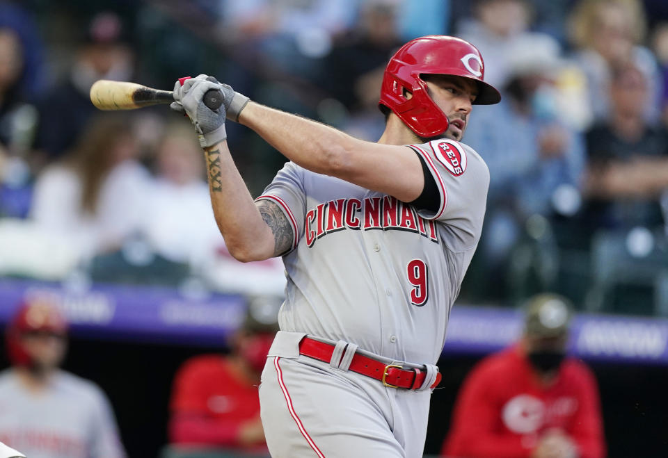 Cincinnati Reds' Mike Moustakas hits a ground ball off Colorado Rockies starting pitcher German Marquez in the third inning of a baseball game Friday, May 14, 2021, in Denver. (AP Photo/David Zalubowski)