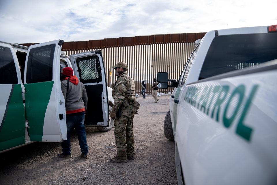 Migrants and asylum seekers are guided into vans to be transported for processing by U.S. Border Patrol agents in Organ Pipe Cactus National Monument along the U.S.-Mexico border about a mile west of Lukeville, Ariz., on Dec. 4, 2023. The Lukeville Port of Entry was closed indefinitely by officials Dec. 4.