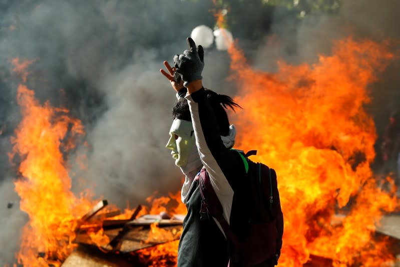 Foto de archivo. Un manifestante enmascarado gesticula frente a una barricada en llamas durante una protesta en Providencia, un barrio acomodado, en Santiago.