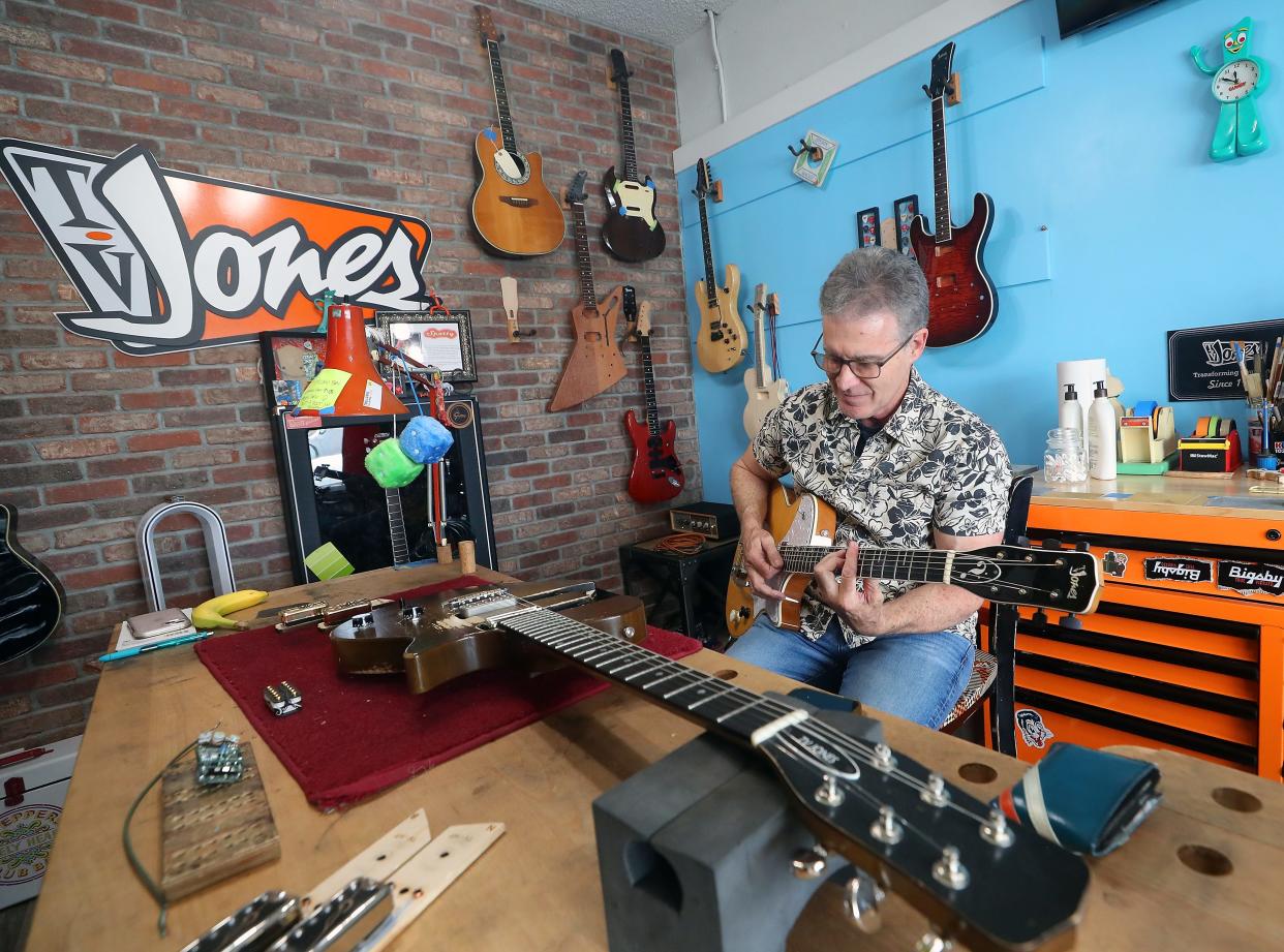 TV Jones founder and president Thomas V. Jones plays one of the many guitars in his Poulsbo shop to demonstrate how the different versions of guitar pickups that they make have different tones, on Thursday, April 11, 2024.