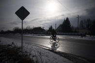 A man rides a bicycle close to the border with Belarus, Ukraine, Wednesday, Feb. 1, 2023. Reconnaissance drones fly several times a day from Ukrainian positions across the border into Belarus, a close Russian ally, scouring for signs of trouble on the other side. Ukrainian units are monitoring the 1,000-kilometer (650-mile) frontier of marsh and woodland for a possible surprise offensive from the north, a repeat of the unsuccessful Russian thrust towards Kyiv at the start of the war nearly a year ago. (AP Photo/Daniel Cole)