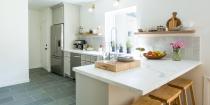 <p>An old half-wall that closed the kitchen space off from the dining room was knocked down and replaced with a large marble peninsula, for a better flow. </p>