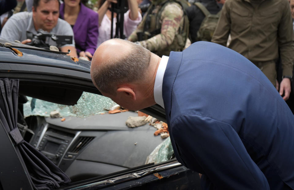 German Chancellor Olaf Scholz inspects a damaged car as he visits Irpin, Ukraine, Thursday, June 16, 2022. The leaders of France, Germany, Italy and Romania arrived in Kyiv on Thursday in a show of collective European support for the Ukrainian people as they resist Russia's invasion, marking the highest-profile visit to Ukraine's capital since Russia invaded its neighbor. (AP Photo/Roman Hrytsyna)