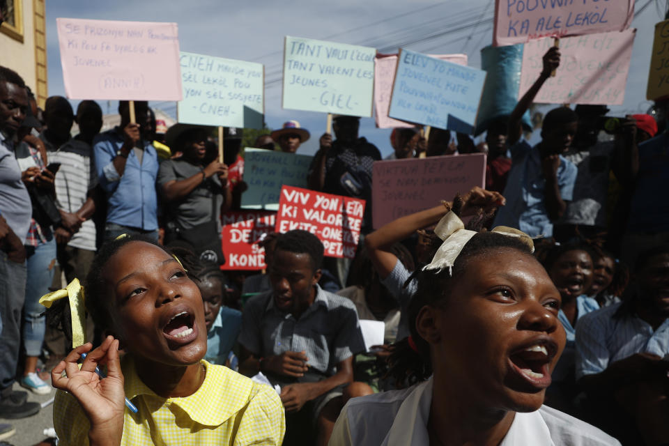 A theater troupe of university students perform as grade school students reciting a lesson on Haiti's constitution and government, during a protest calling for President Jovenel Moïse to resign so that schools can reopen, in Port-au-Prince, Haiti, Monday, Oct. 21, 2019. Many schools around the country have now been closed for more than a month as protests block roads and paralyze the economy. The United Nations said in early October that roughly 2 million children were unable to go to school due to the unrest. (AP Photo/Rebecca Blackwell)