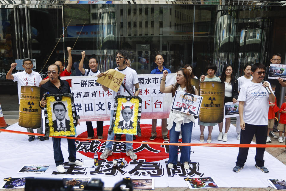 Protesters hold up placards depicting Japanese Prime Minister Fumio Kishida and Rafael Mariano Grossi, Director General of the International Atomic Energy Agency to protest against the discharge of treated Fukushima radioactive wastewater, outside the Japan general-consulate in Hong Kong, on Thursday, Aug. 24, 2023. The Hong Kong authorities have imposed a ban on imports of Japanese seafood as a gesture to oppose Japan's decision to discharge the treated radioactive water from the wrecked Fukushima nuclear power plant. (AP Photo/Daniel Ceng)