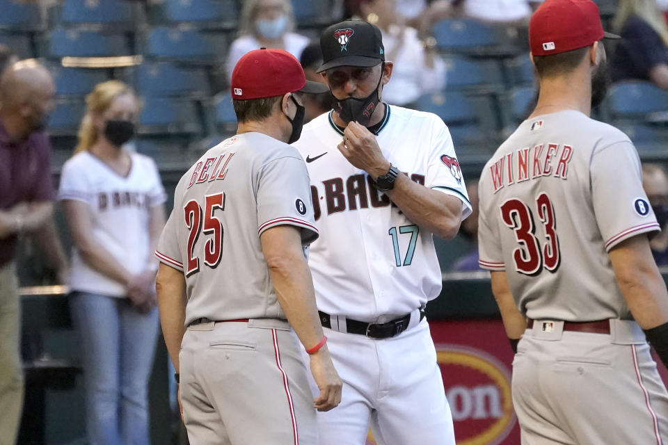 Arizona Diamondbacks manager Torey Lovullo (17) greets Cincinnati Reds manager David Bell (25) prior to a baseball game against the Cincinnati Reds, Friday, April 9, 2021, in Phoenix. (AP Photo/Matt York)