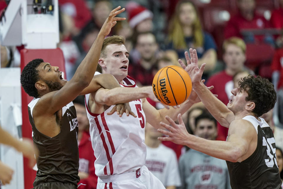 Lehigh's Jakob Alamudun, left, and Dominic Parolin (35) battle for a rebound against Wisconsin's Tyler Wahl (5) during the first half of an NCAA college basketball game Thursday, Dec. 15, 2022, in Madison, Wis. (AP Photo/Andy Manis)