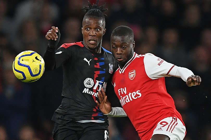 Wilfried Zaha and Nicolas Pepe battle for the ball