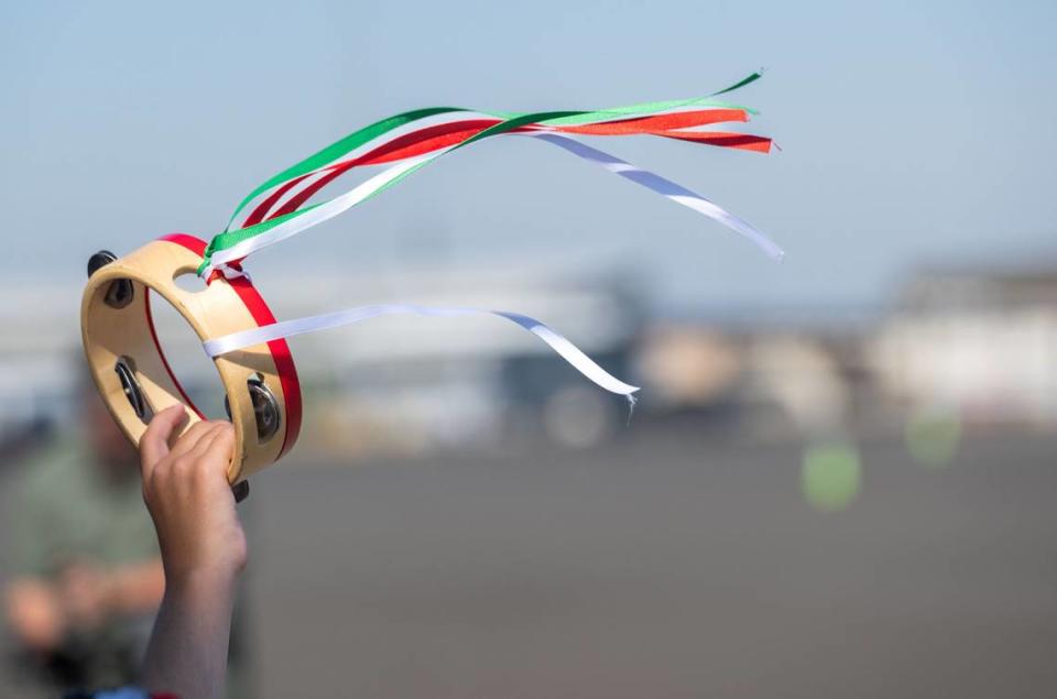 An onlooker waves a tambourine in greeting to Frecce Tricolori jet team pilots at Mather Airport near Rancho Cordova on Tuesday. The ribbons of green, white and red correspond with Italy’s tricolor flag.