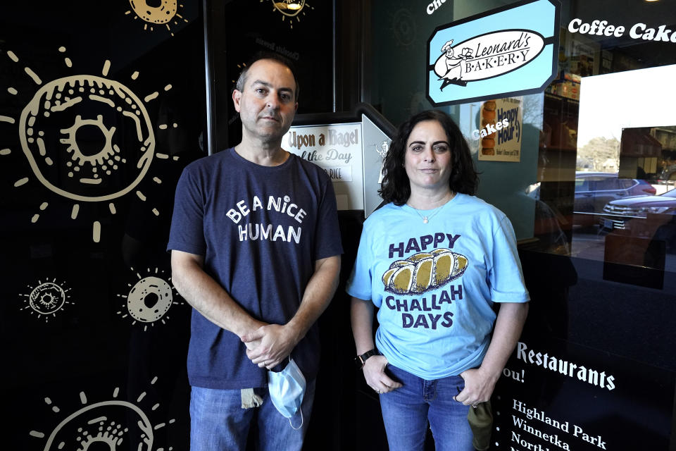 Steve Geffen, left, and his wife Shana Geffen pose for a photo at Once Upon a Bagel restaurants in Highland Park, Ill., Thursday, Dec. 16, 2021. U.S. restaurants are entering their second winter of the pandemic on firmer footing. Their doors are open, and many dining rooms are full again. But the industry remains anxious, squeezed by labor shortages and food prices and unsure if the omicron variant will once again drive diners away. (AP Photo/Nam Y. Huh)