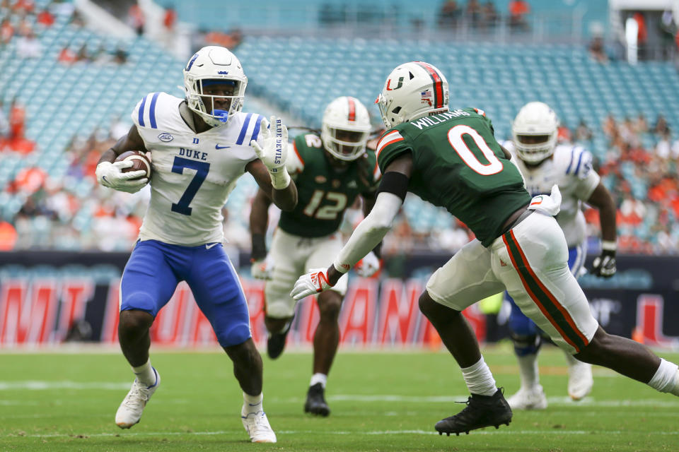 Oct 22, 2022; Miami Gardens, Florida, USA; Duke Blue Devils running back Jordan Waters (7) runs with the football as Miami Hurricanes safety James Williams (0) defends during the first quarter at Hard Rock Stadium. Mandatory Credit: Sam Navarro-USA TODAY Sports
