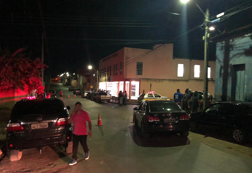 This photo released by Agora News shows a street view near the Baptist church, in background on right, where a man killed three people after he knifed his girlfriend in her home, in Paracatu, Minas Gerais state, Brazil, Tuesday, May 21, 2019. The gunman was then shot and wounded by military police at the church. Authorities did not provide a motive for the attack, but said the wounded man had been expelled by the church for "problems of behavior." (Marco Aurelio Costa/Agora News via AP)