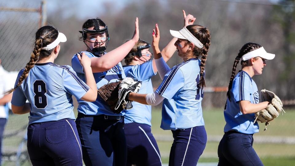 East Bridgewater's Gillian Oliver, left, and Riley Egan high-five pitcher Maggie Schlossberg during a game against Bristol-Plymouth on Monday, April 10, 2023.