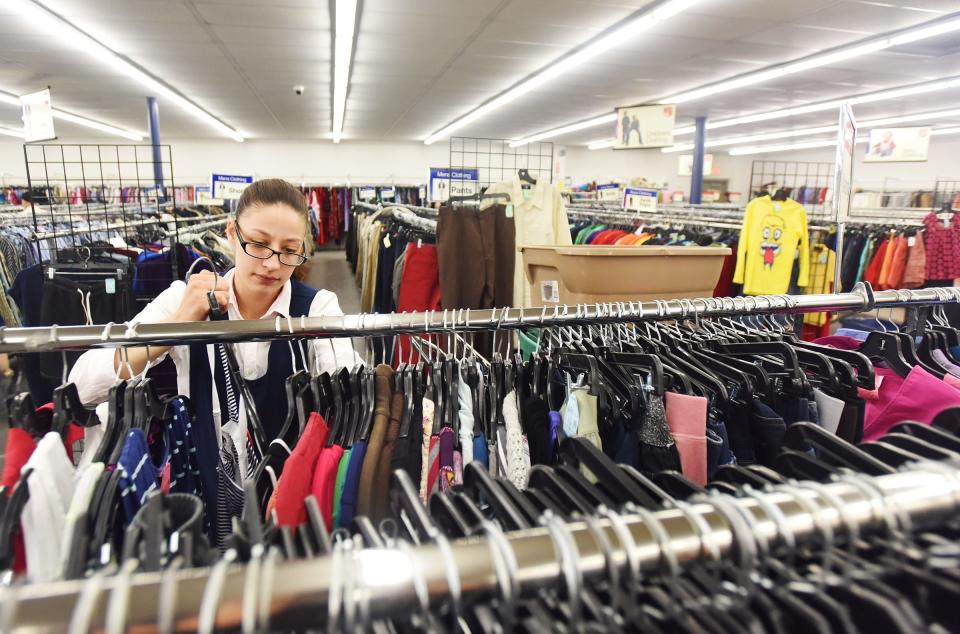 Melloney Stevens, a senior sales associate, sorts through clothes at the Salvation Army store in Utica Thursday, May 23, 2019.