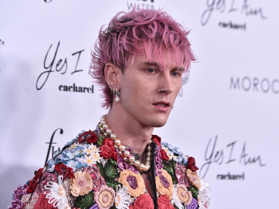 Machine Gun Kelly with pink hair and in a flower-embellished jacket.