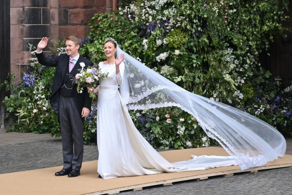 The Duke and Duchess of Westminster waving at their wedding.