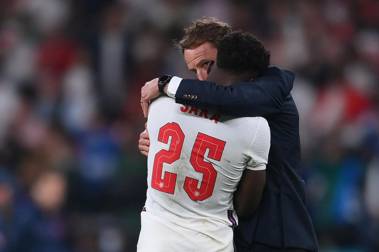 England's coach Gareth Southgate speaks to England's midfielder Bukayo Saka after their loss in the UEFA EURO 2020 final football match between Italy and England at the Wembley Stadium in London on July 11, 2021. (Photo by Laurence Griffiths / POOL / AFP) (Photo by LAURENCE GRIFFITHS/POOL/AFP via Getty Images)