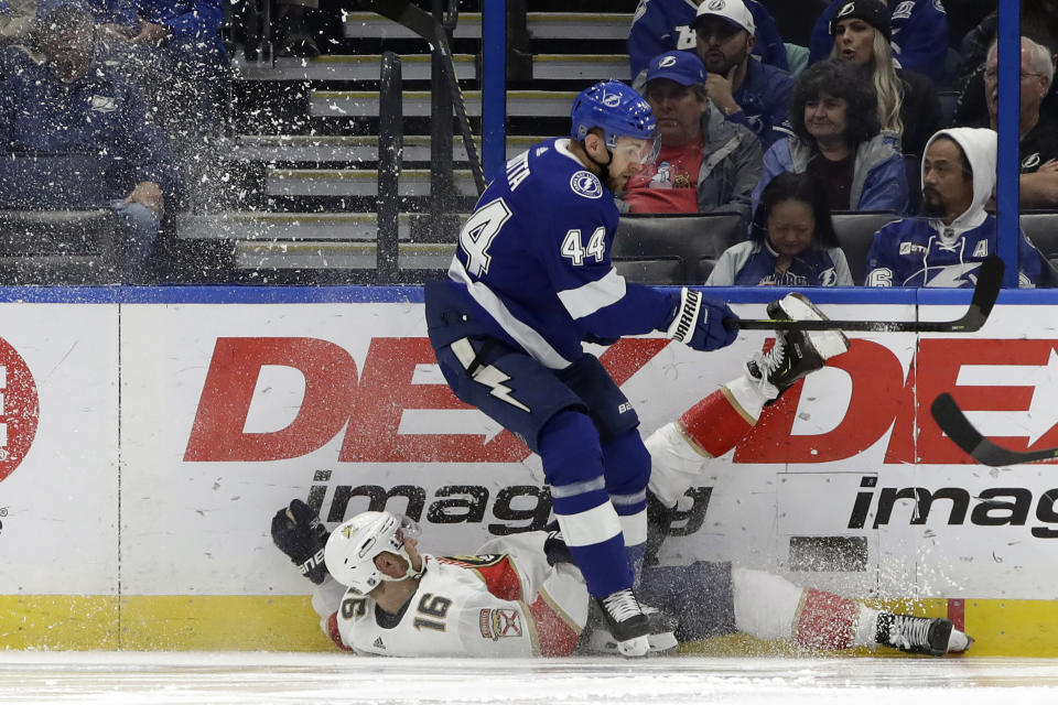 Tampa Bay Lightning defenseman Jan Rutta (44) sends Florida Panthers center Aleksander Barkov (16) to the ice during the second period of an NHL hockey game Monday, Dec. 23, 2019, in Tampa, Fla. (AP Photo/Chris O'Meara)