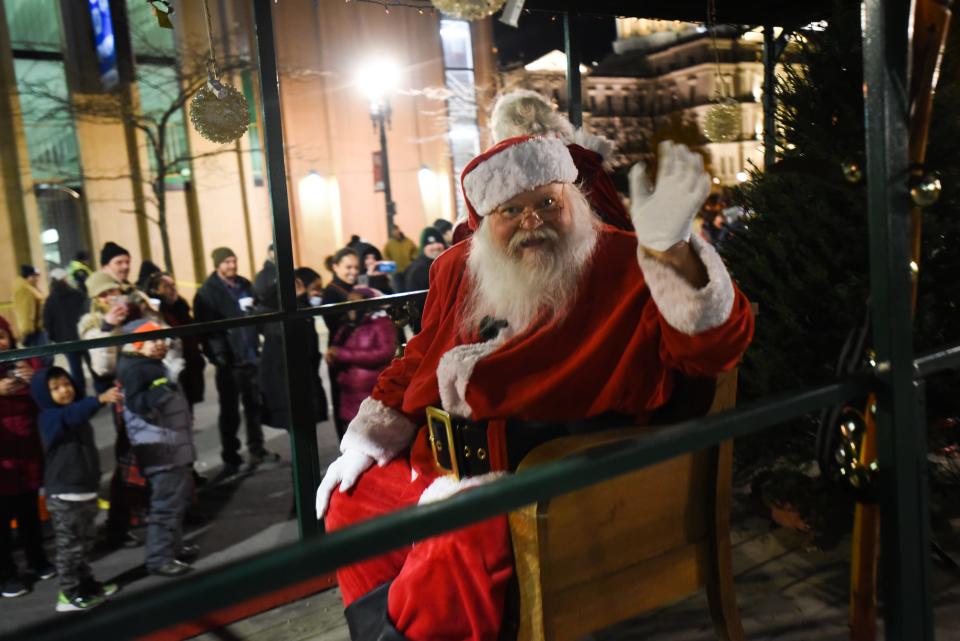 Santa Claus waves to parade goers during the Silver Bells in the City Electric Light Parade in downtown Lansing, Friday, Nov. 19, 2021.