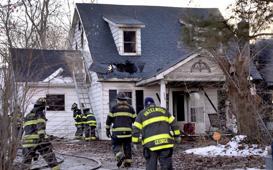 Firefighters pick up their equipment after they extinguished a fire in a home on Monday, Feb. 19, 2024 in Ferguson, Mo. A mother and four children died early Monday as police say the fire is being investigated as "suspicious." (David Carson/St. Louis Post-Dispatch via AP)