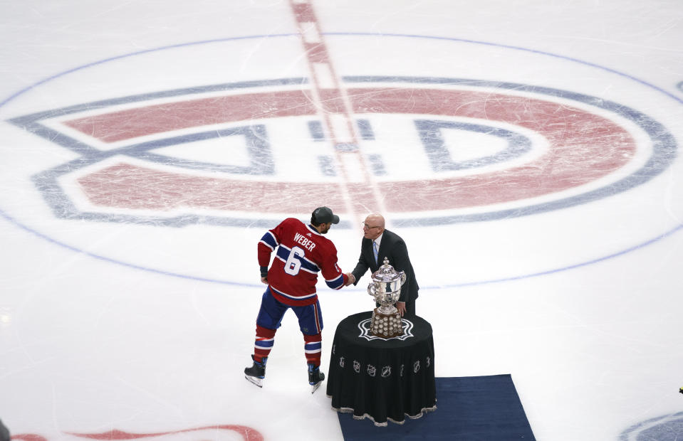 Montreal Canadiens' Shea Weber (6) is presented with the Clarence Campbell trophy by Bill Daly after the team's victory in overtime of Game 6 of an NHL hockey Stanley Cup semifinal playoff series against the Vegas Golden Knights Thursday, June 24, 2021 in Montreal. (Paul Chiasson/The Canadian Press via AP)