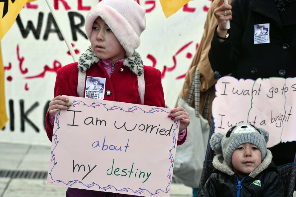 A child carries a sign as migrants and refugees demonstrate in Athens on January 21, 2017.