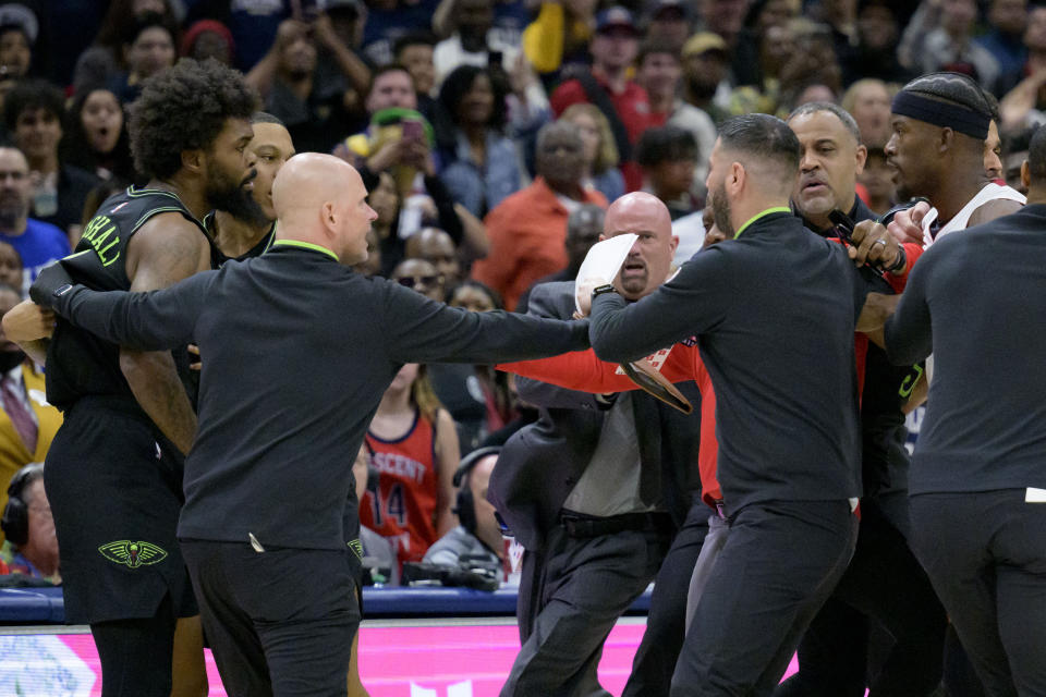 New Orleans Pelicans forward Naji Marshall, left, and Miami Heat forward Jimmy Butler, right, get into a scuffle during the second half of an NBA basketball game in New Orleans, Friday, Feb. 23, 2024. Marshall and Butler were later ejected. (AP Photo/Matthew Hinton)
