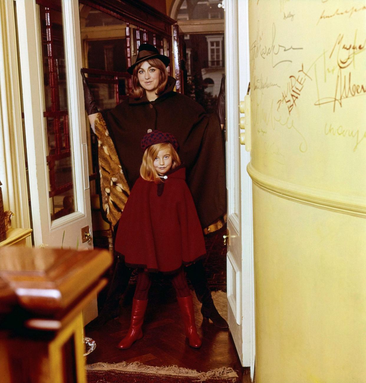 Diana Phipps and her daughter, Alexandra, in the entrance hall of their London house: on the wall are signatures of her guests, including David Bailey and Jocelyn Stevens