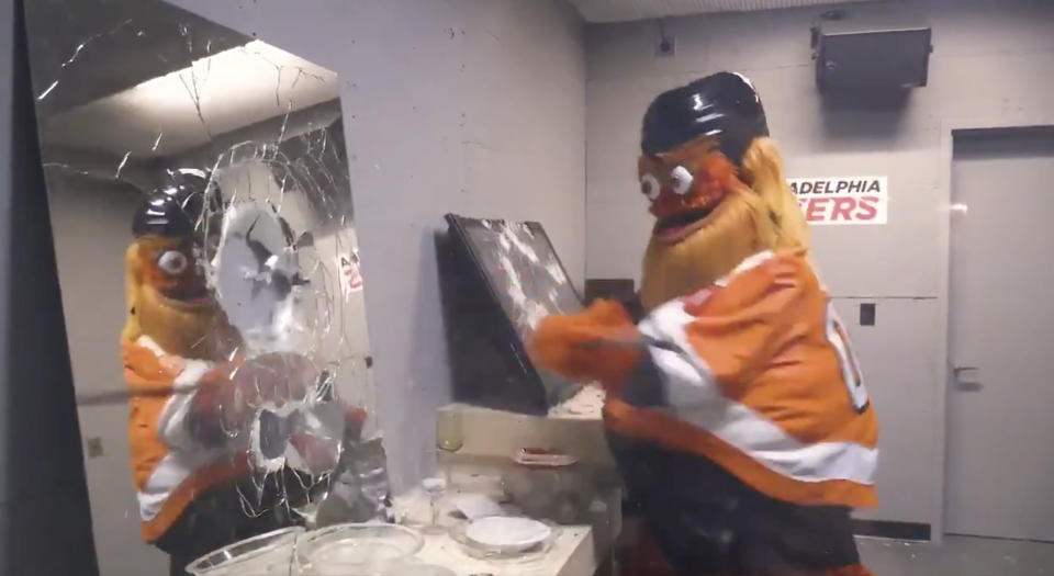 Gritty, the mascot of the Philadelphia Flyers, does a number on a mirror in the new rage room within the Wells Fargo Center. (Twitter//@NHLFlyers)