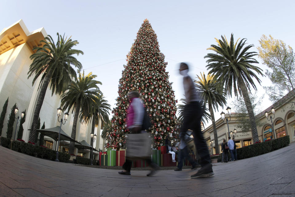 FILE - In this Thursday, Dec. 20, 2012 file photo, holiday shoppers walk past a large Christmas tree at a shopping center in Newport Beach, Calif. On Friday, March 29, 2019, The Associated Press has found that stories circulating on the internet that Muslims in California are asking people to not decorate for Easter or Christmas in 2019 out of respect, are untrue. (AP Photo/Chris Carlson)