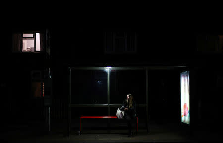A woman sits at a bus stop in Dagenham, east London, Britain, March 18, 2019. Picture taken March 18, 2019. REUTERS/Hannah McKay