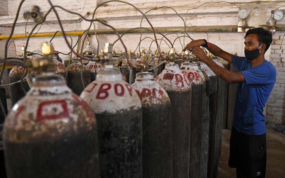 Workers are seen sorting oxygen cylinders that are being used for Covid-19 coronavirus patients  - Narinder Nanu/AFP