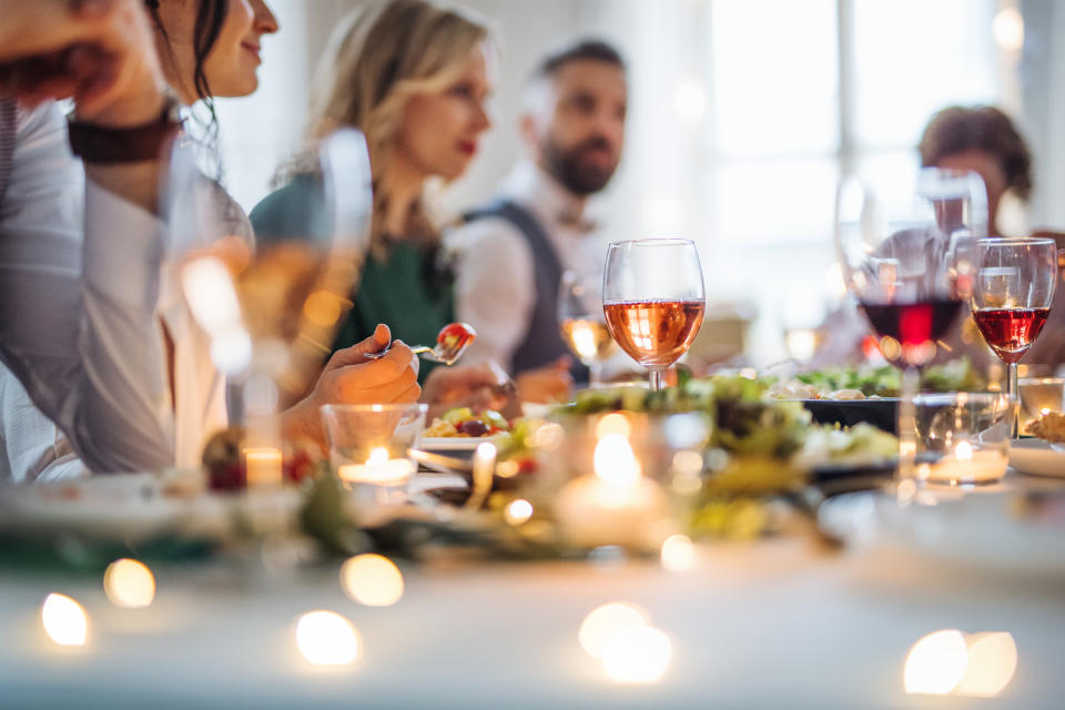 A happy big family sitting at a table on a indoor birthday party, eating.