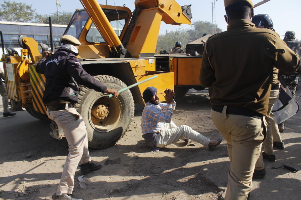 FILE - In this Friday, Nov. 27, 2020, file photo, a farmer pleads with policemen as they beat him during a protest at the border between Delhi and Haryana state. Prime Minister Narendra Modi's government also initially tried to discredit the farmers — who happen to be largely Sikh because of the demographics of the agricultural powerhouse states — by dismissing their concerns as motivated by religious nationalism.But such allegations appear to have backfired, further angering the farmers, many of whom serve in the Indian army, police and civil service. Since then, common citizens also joined them and the protests have gathered strength. (AP Photo/File)