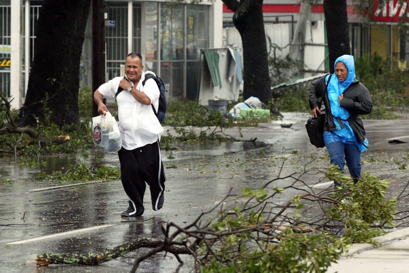A couple runs down Canal Street in New Orleans as Hurricane Katrina slams into tNew Orleans on August 29, 2005. File Photo by A.J. Sisco/UPI