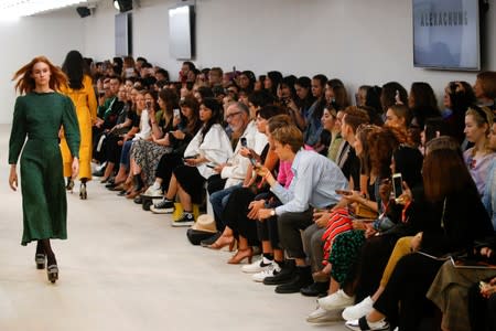 Members of the public watch models present creations at the Alexa Chung public catwalk show during London Fashion Week in London