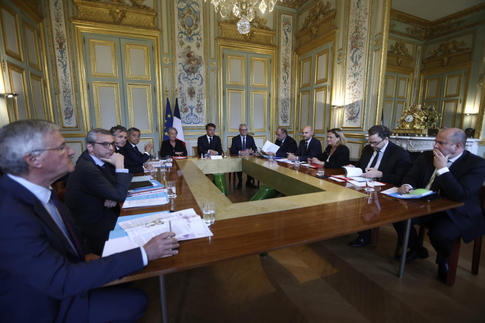 French President Emmanuel Macron, center, chairs a government emergency meeting at the emergency crisis center of the Interior Ministry in Paris, Sunday, July 2, 2023 after a 17-year-old whose killing by police has triggered days of rioting and looting across the nation. (Mohamed Badra, Pool via AP)