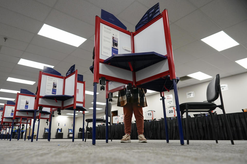 A voter stands in a partitioned booth and fills out a ballot during early in-person voting at the Hamilton County Board of Elections in Cincinnati, Wednesday, Oct. 11, 2023. (AP Photo/Carolyn Kaster)